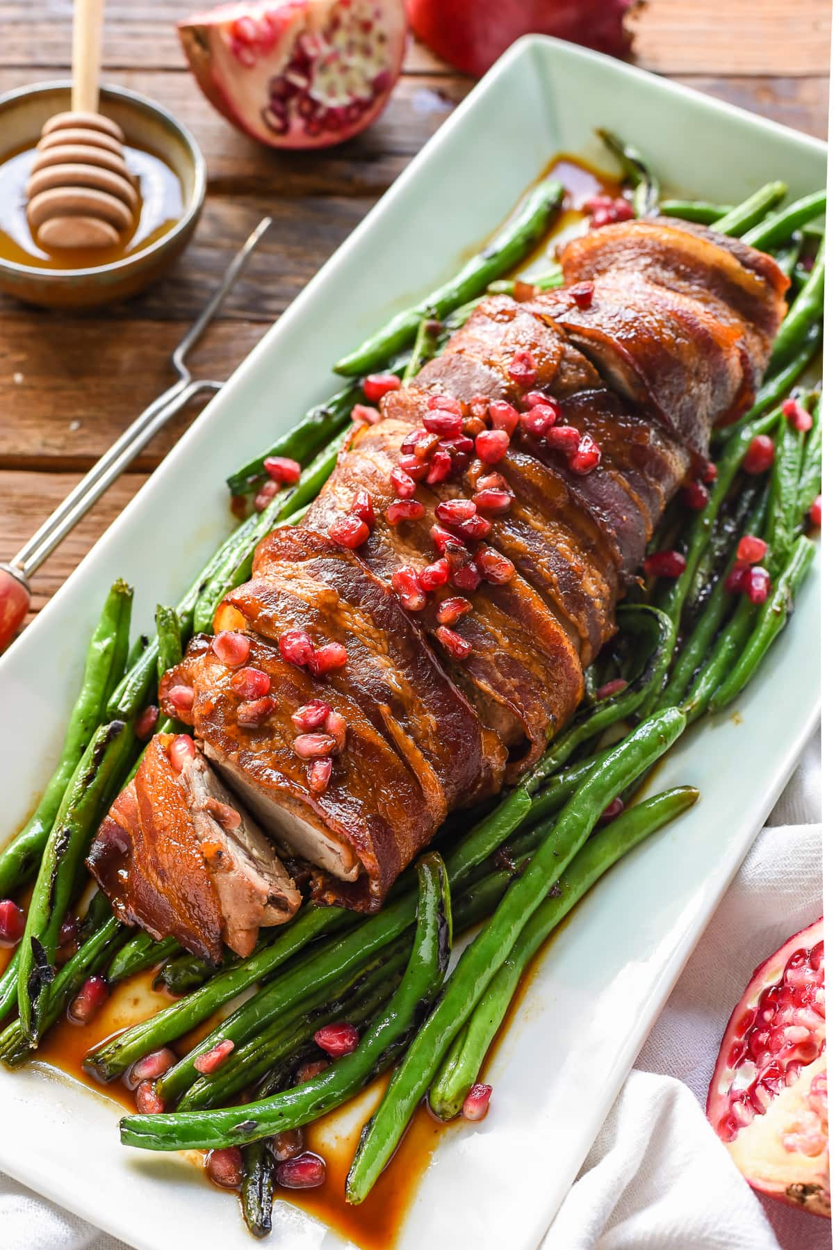 This Bacon Wrapped Pork Tenderloin with a Honey Pomegranate Glaze is a super easy and festive meal for the holidays.
