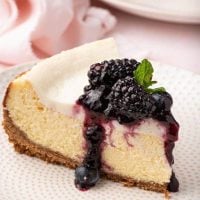 cheesecake slice with sour cream topping and blueberry preserves
