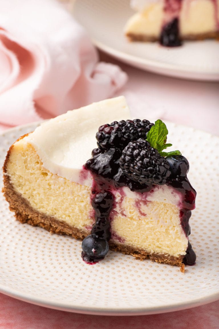 cheesecake slice with sour cream topping and blueberry preserves