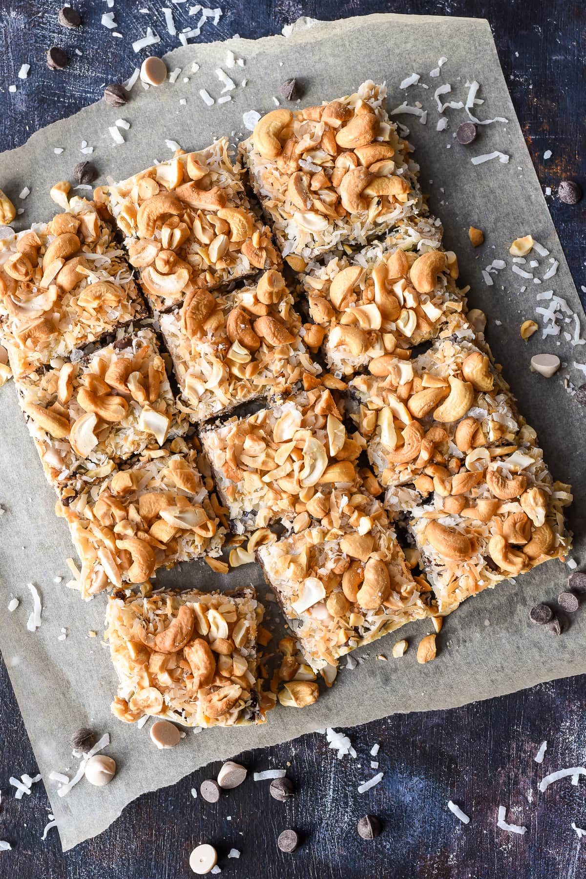 7 layer bars served on a piece of parchment surrounded by coconut and chips