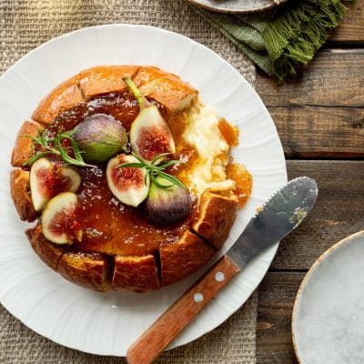 Air Fryer Baked Brie with fig jam on a plate, topped with fresh figs.