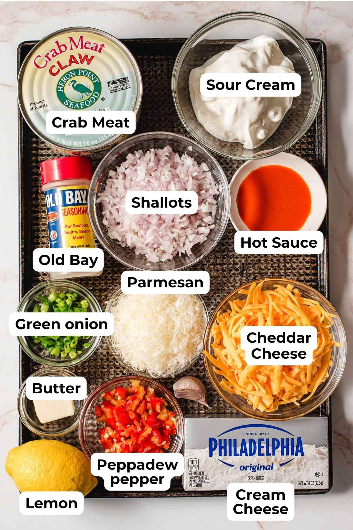 Ingredients for crab dip arranged on a baking sheet.