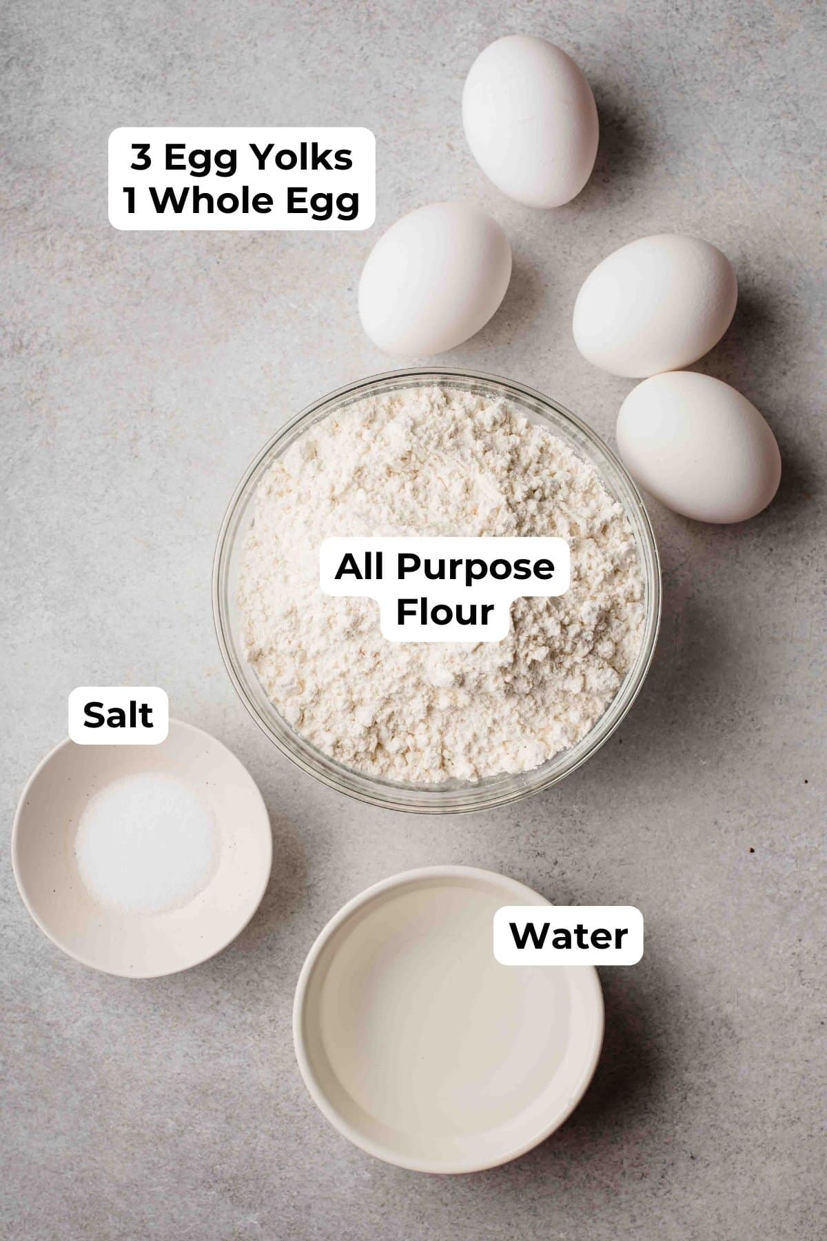4 eggs, flour, salt, and water on a countertop