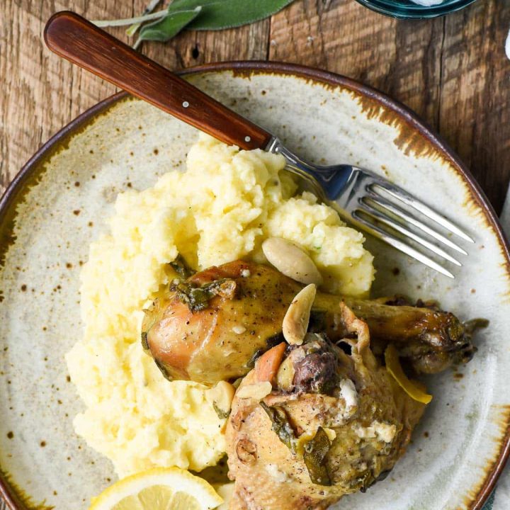 Chicken thigh and drumstick braised in coconut milk with lemon and garlic, plated over mashed potatoes.