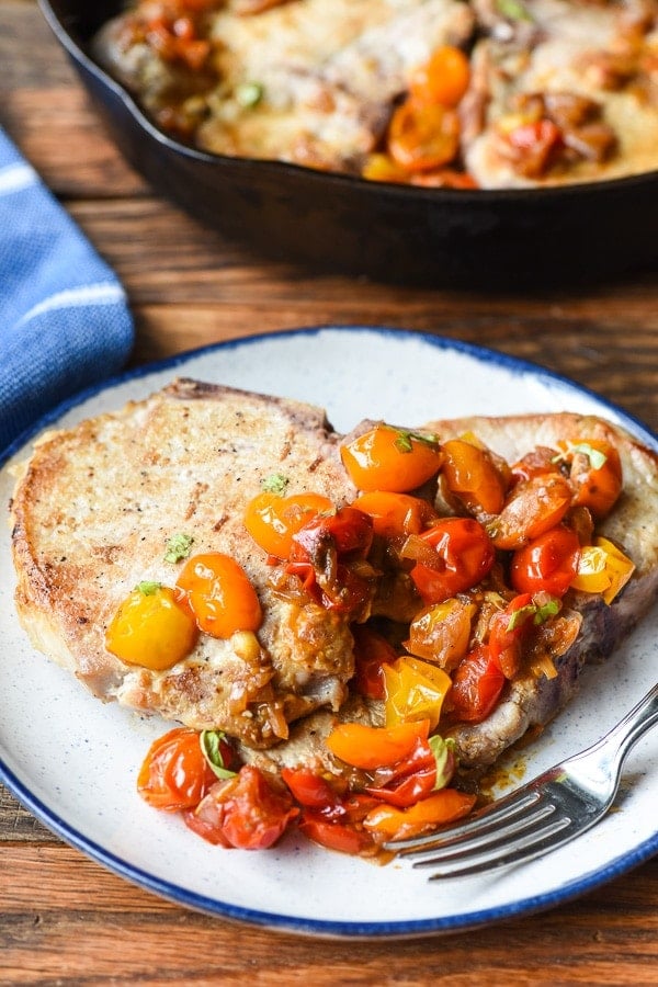 Skillet Pork Chops on a plate with tomato shallot sauce