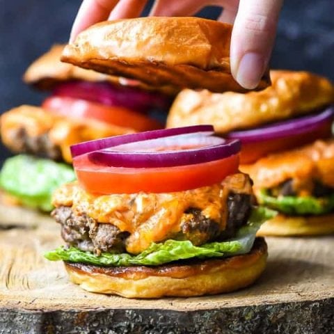 Pimento Cheese Burger with bun being placed on top