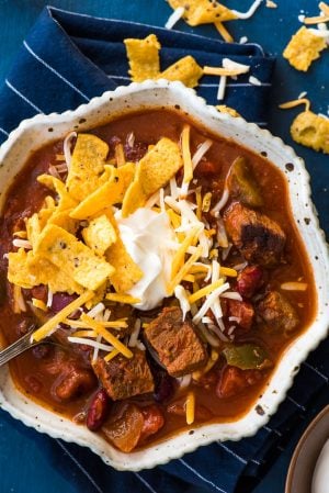 Slow Cooker Steak Chili with cheese, sour cream, and fritos