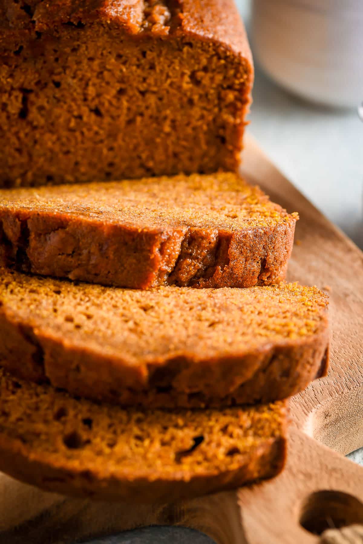 Easy pumpkin bread recipe, shown sliced on a cutting board.