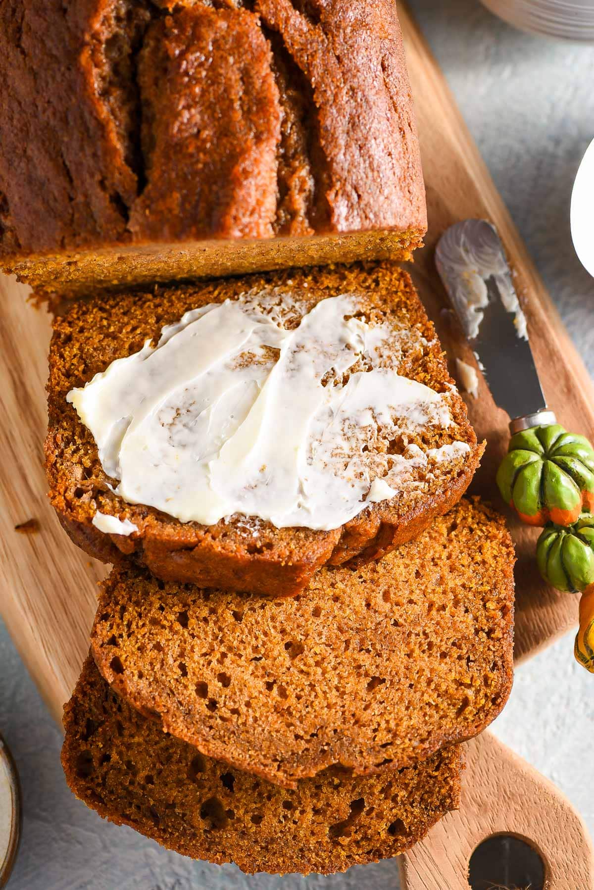 Slices of pumpkin bread slathered with cream cheese.