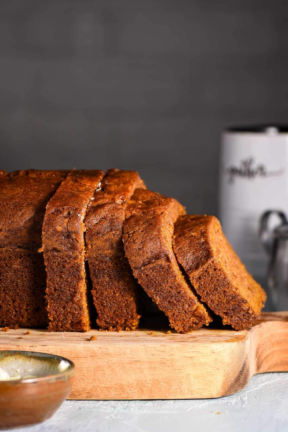 Sliced loaf of pumpkin bread on a cutting board.