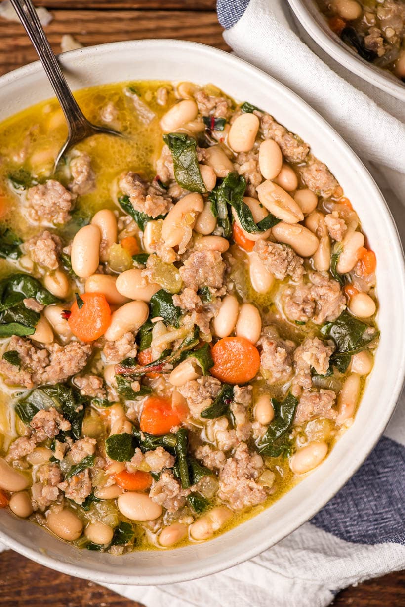 Italian sausage stew with white beans and chard in a bowl