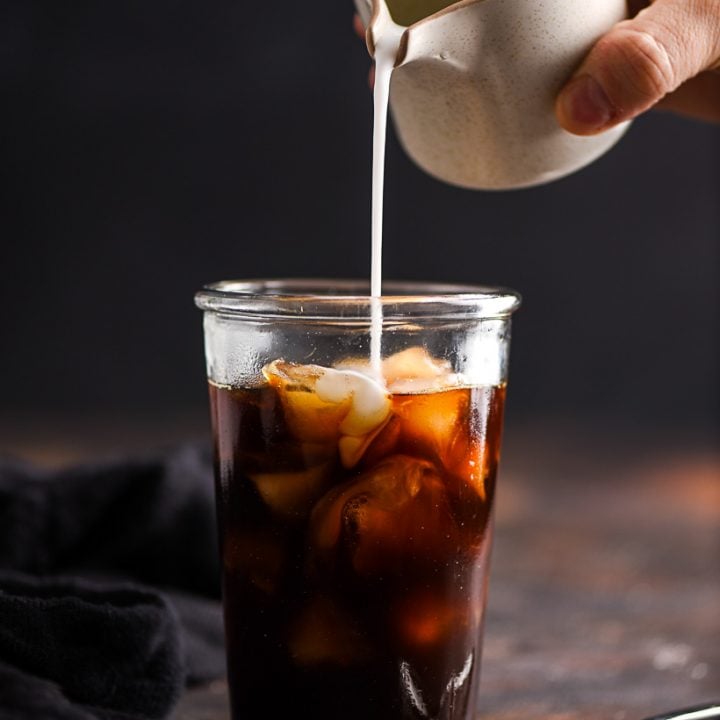 Iced Coffee with coconut milk being poured into it