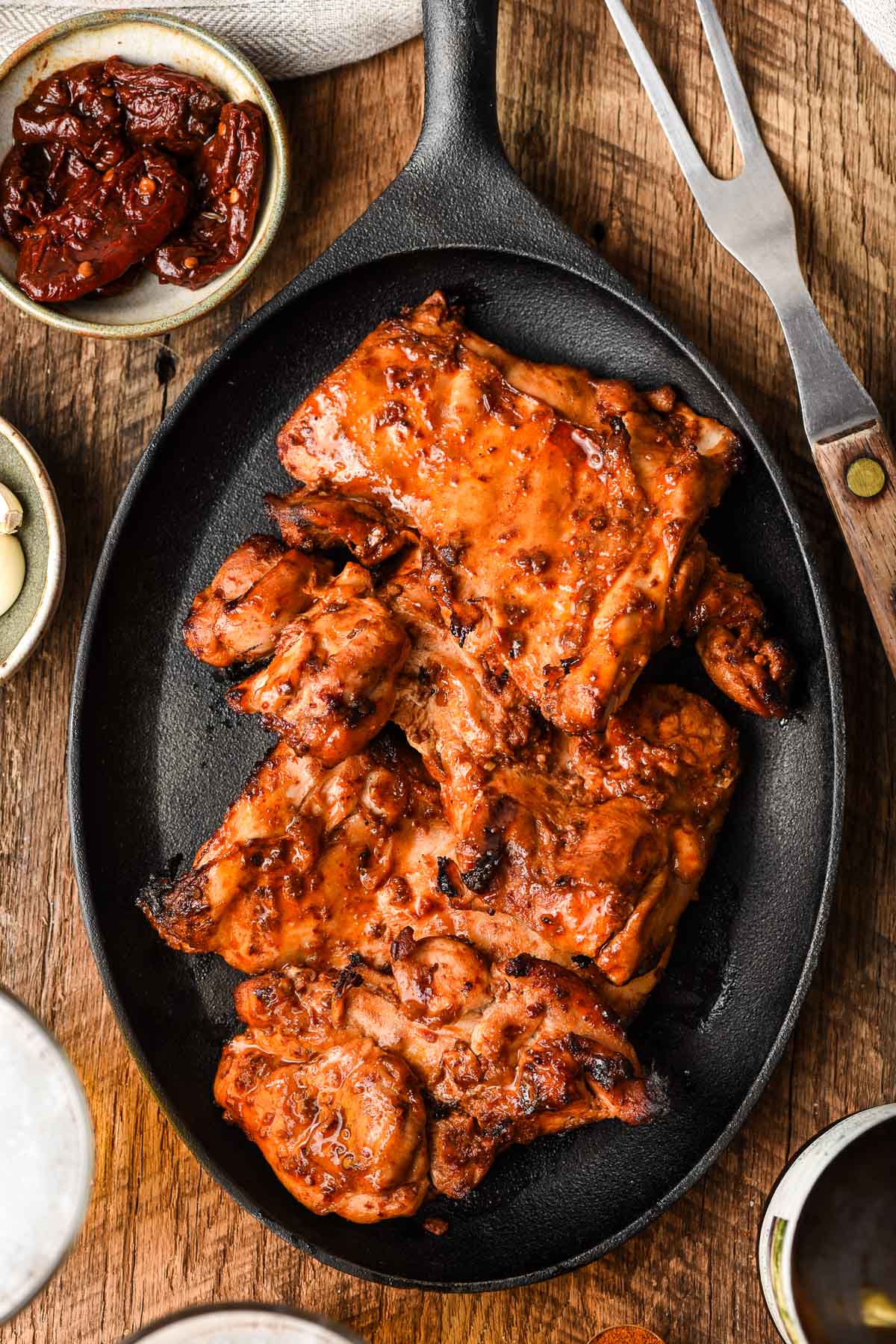 Cast iron oval with grilled chicken in a spicy marinade.