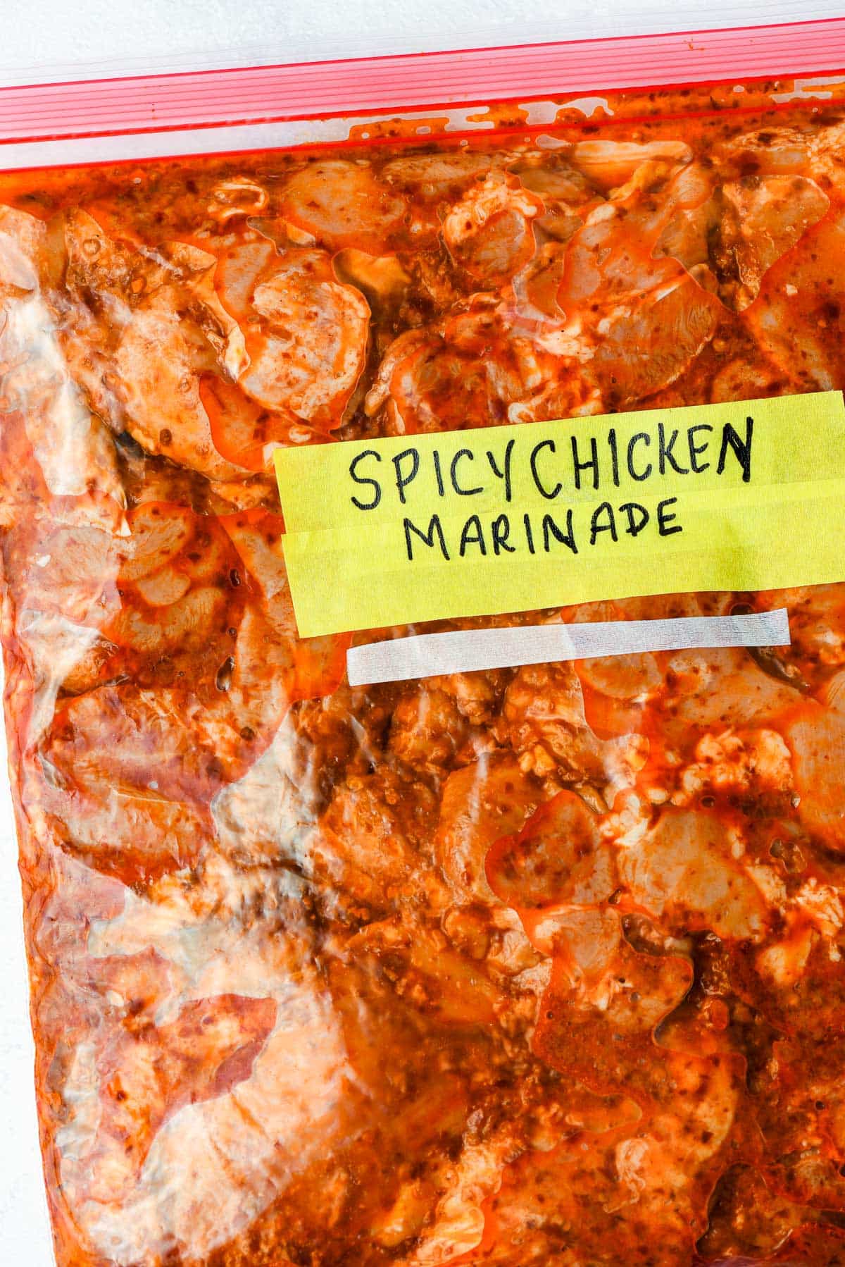 Chicken in a spicy marinade in a zip lock bag.