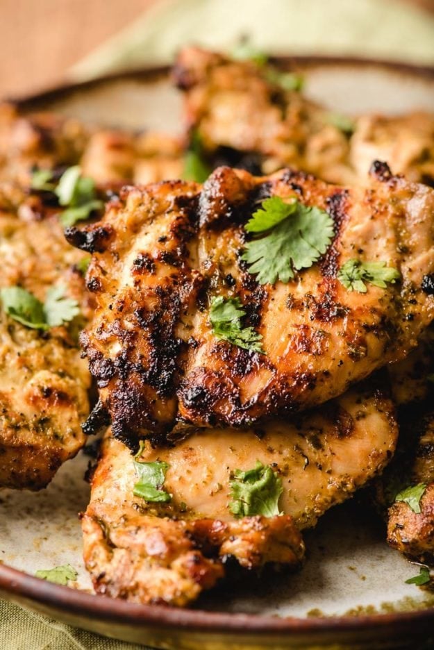 closeup of Mexican grilled chicken on a plate with cilantro