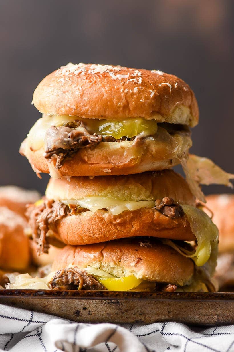 a stack of 3 roast beef sliders on a tray with a napkin