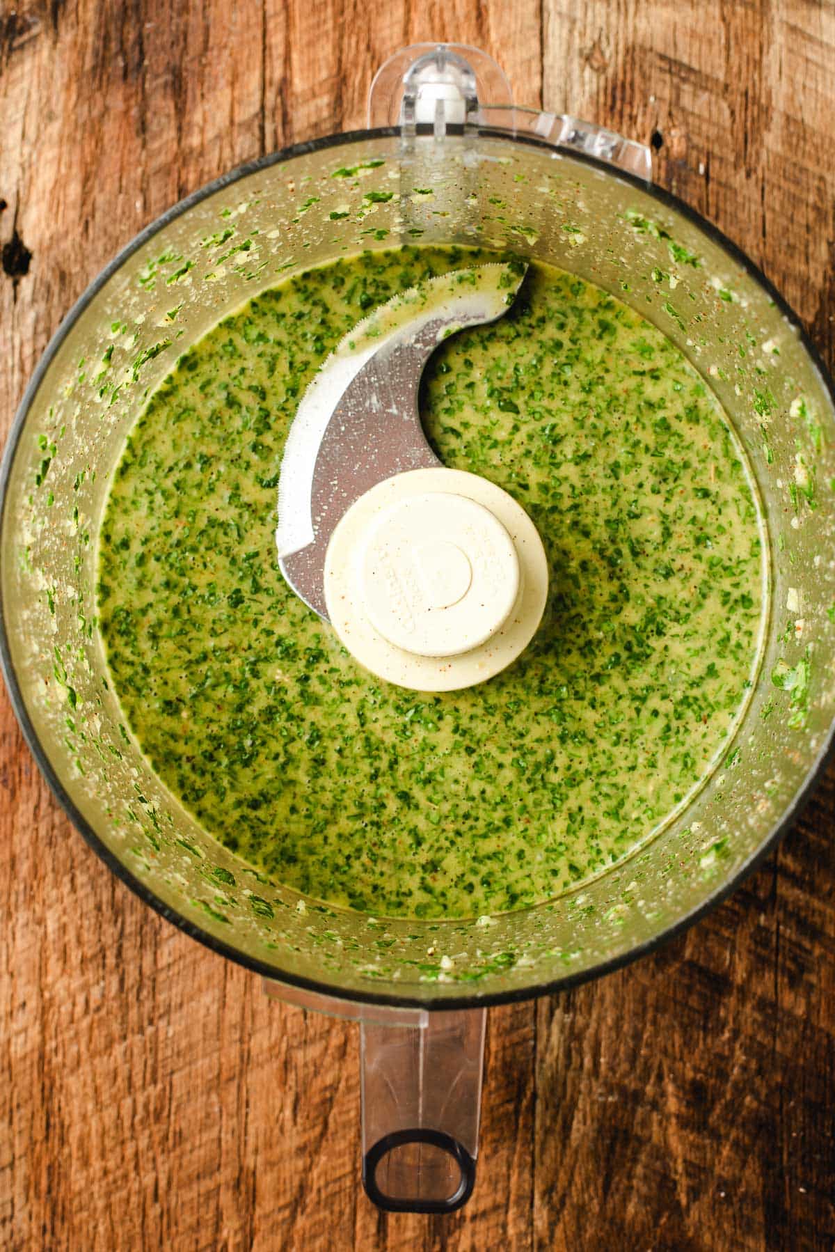 Cilantro, lime, olive oil, and seasonings combined in a food processor.