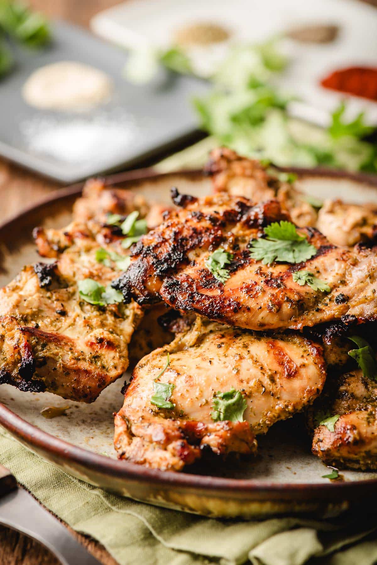 Mexican marinated chicken on a plate, topped with cilantro.