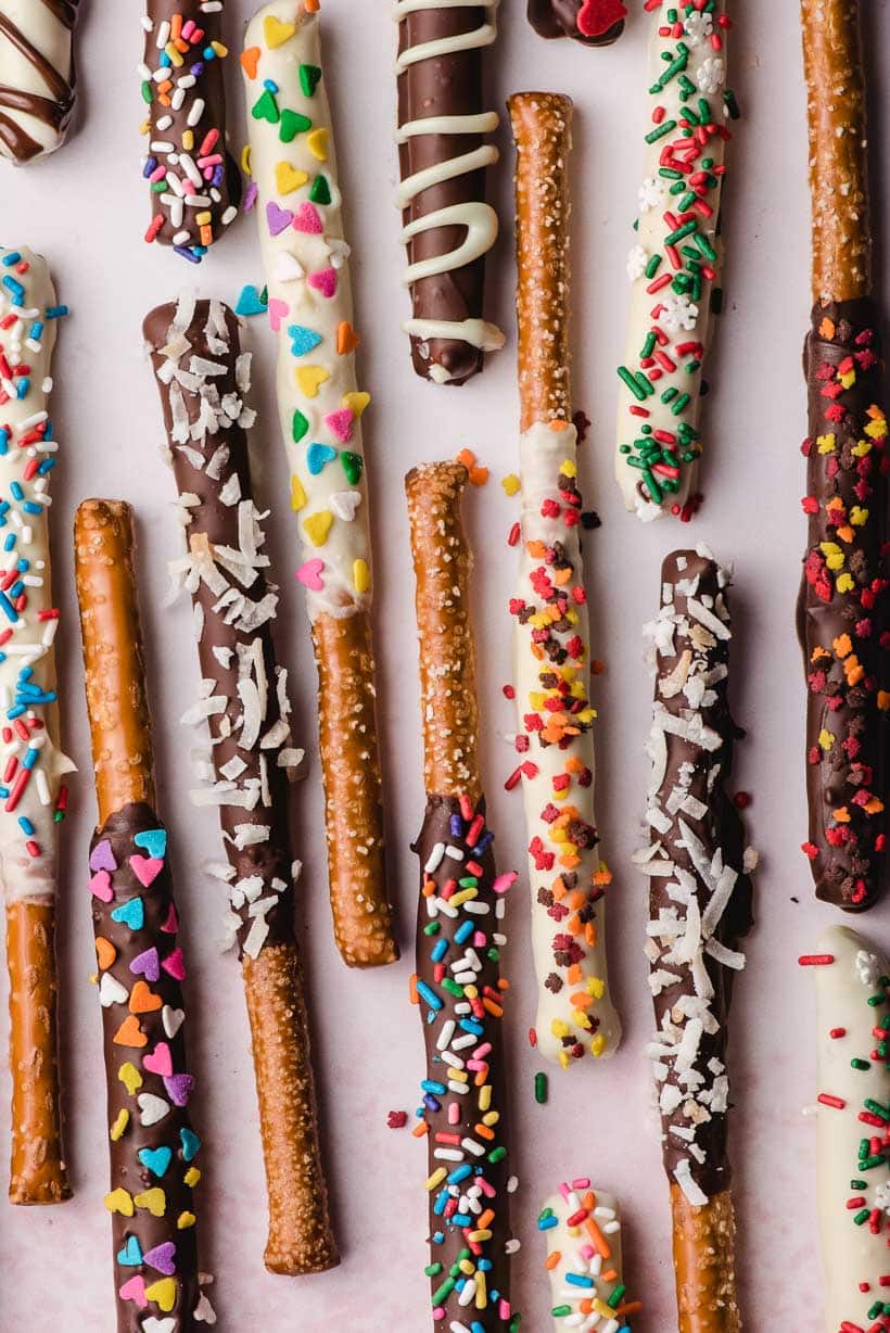 chocolate dipped pretzel rods with a variety of sprinkles