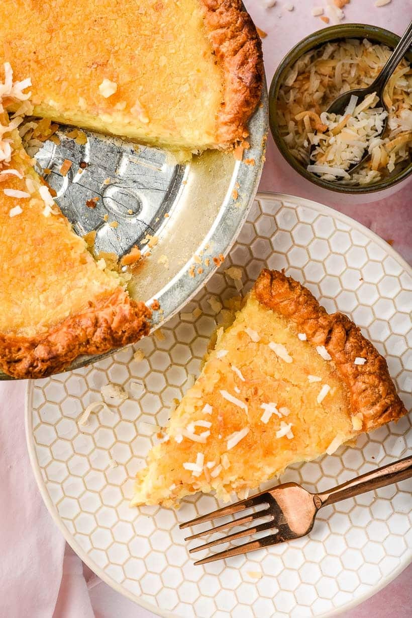 custard pie in a silver pie tin with one sliced removed and plated