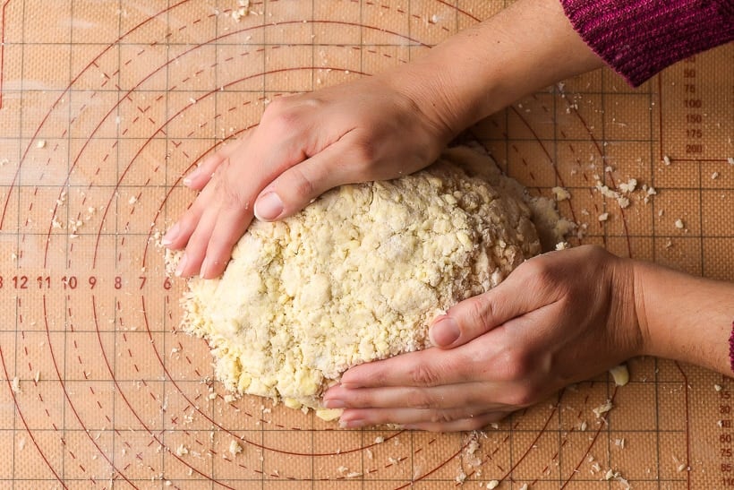 hands bringing together homemade pie crust
