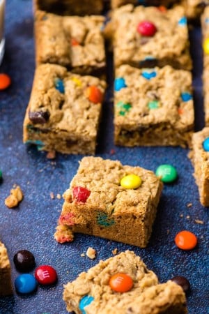 Slices of Monster Cookie Bars arranged on a dark background