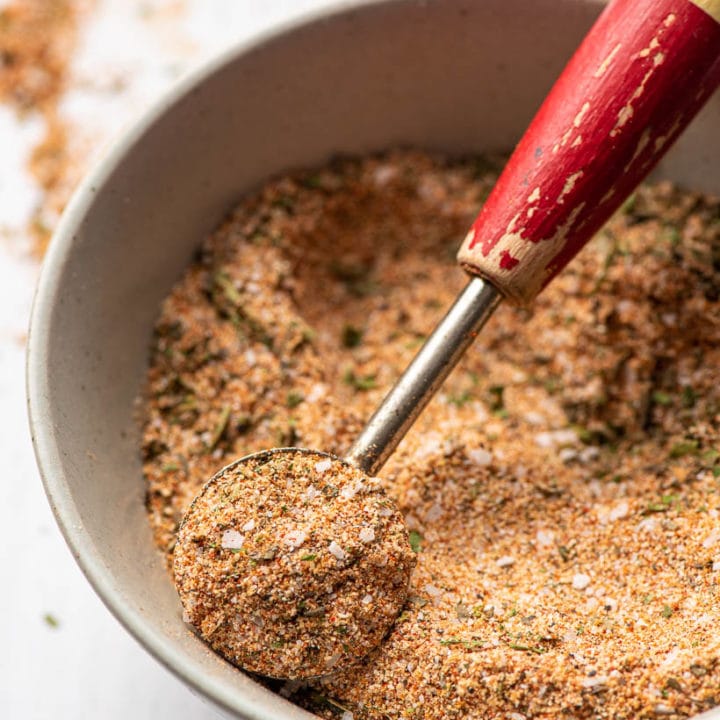 chicken seasoning being scooped out of a bowl