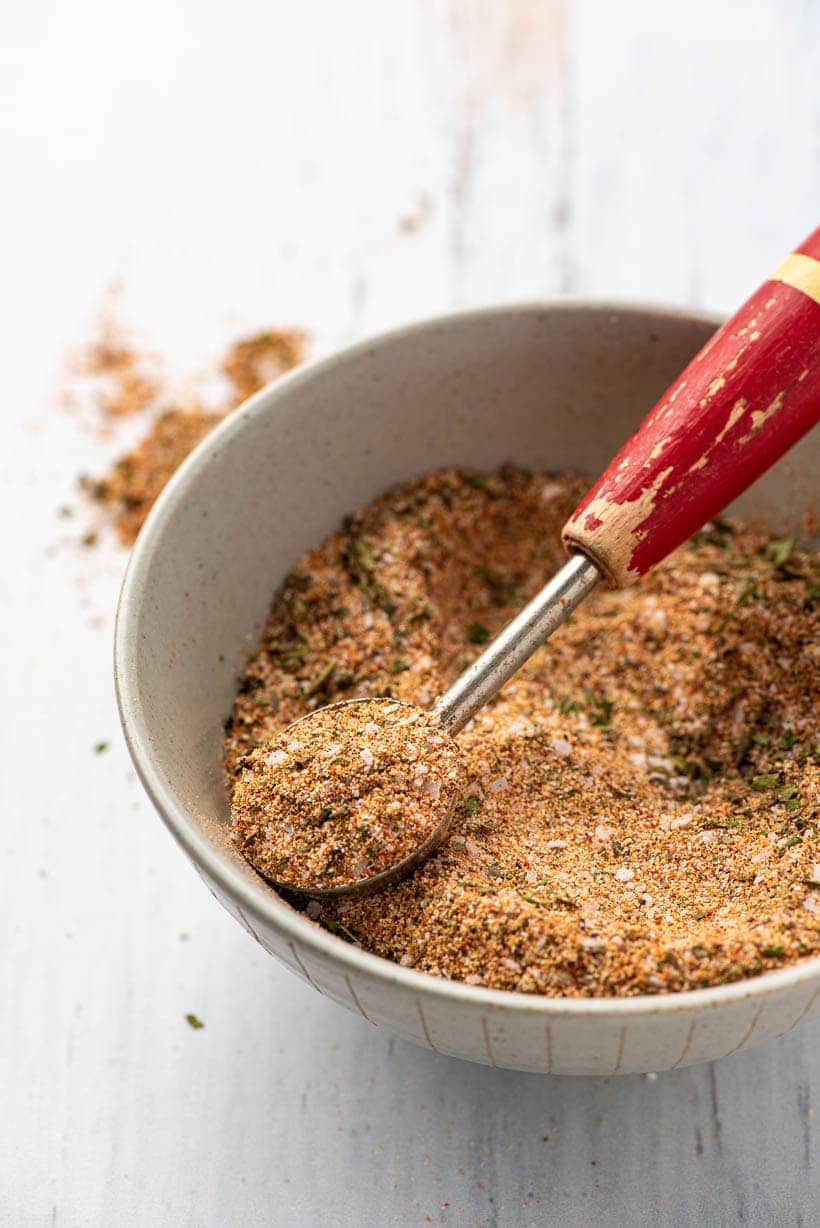 teaspoon scooping chicken seasoning out of a bowl