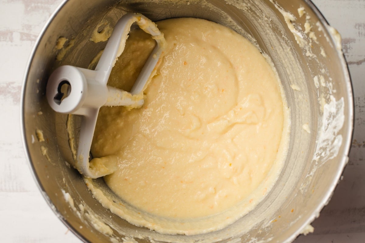 Eggs, sour cream, and vanilla added to creamed butter and sugar in a mixing bowl.
