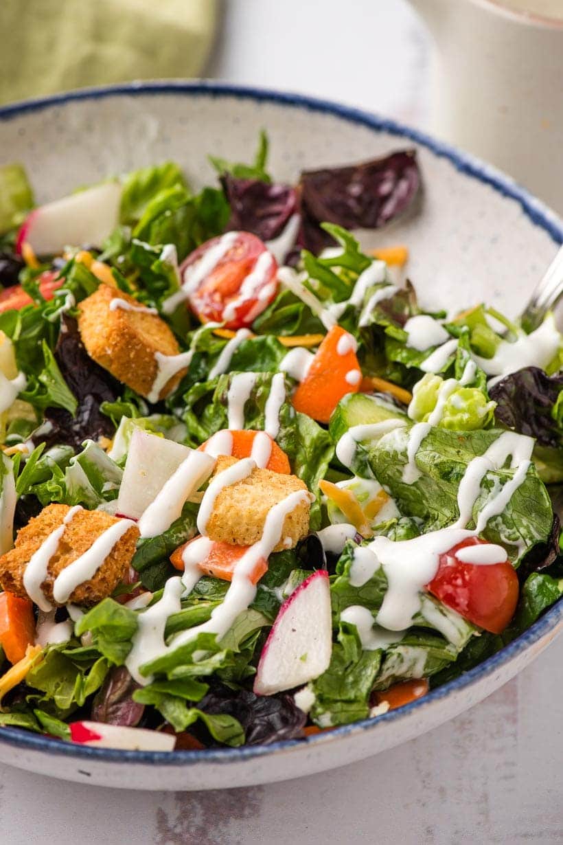 bowl of garden salad with ranch dressing