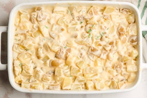 Homemade cheese sauce stirred together with diced potatoes in a casserole dish.