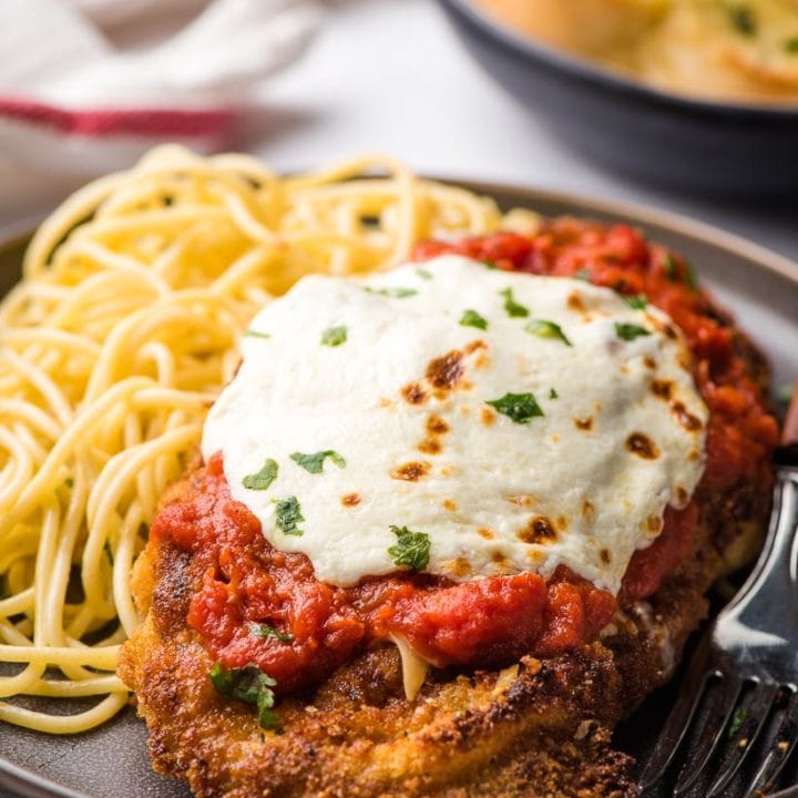 veal parmesan on a plate with pasta
