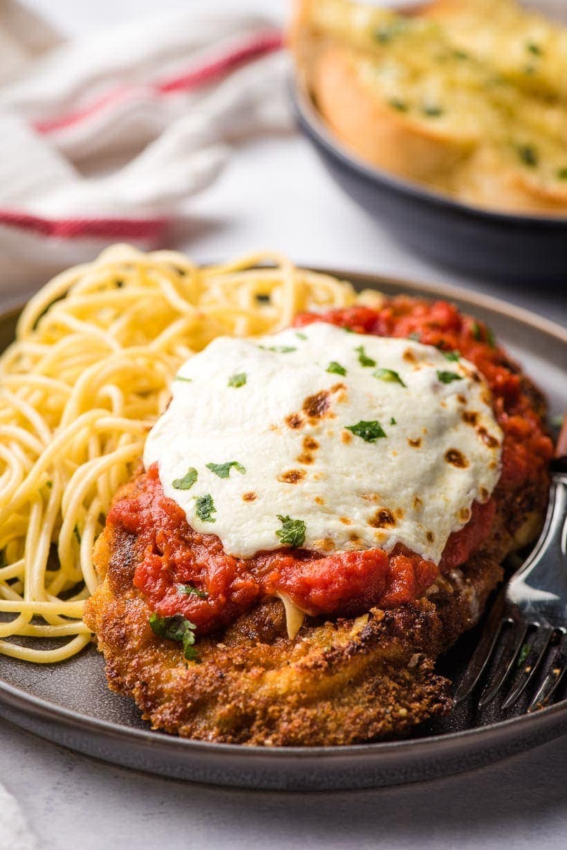 veal parmesan on a plate with pasta