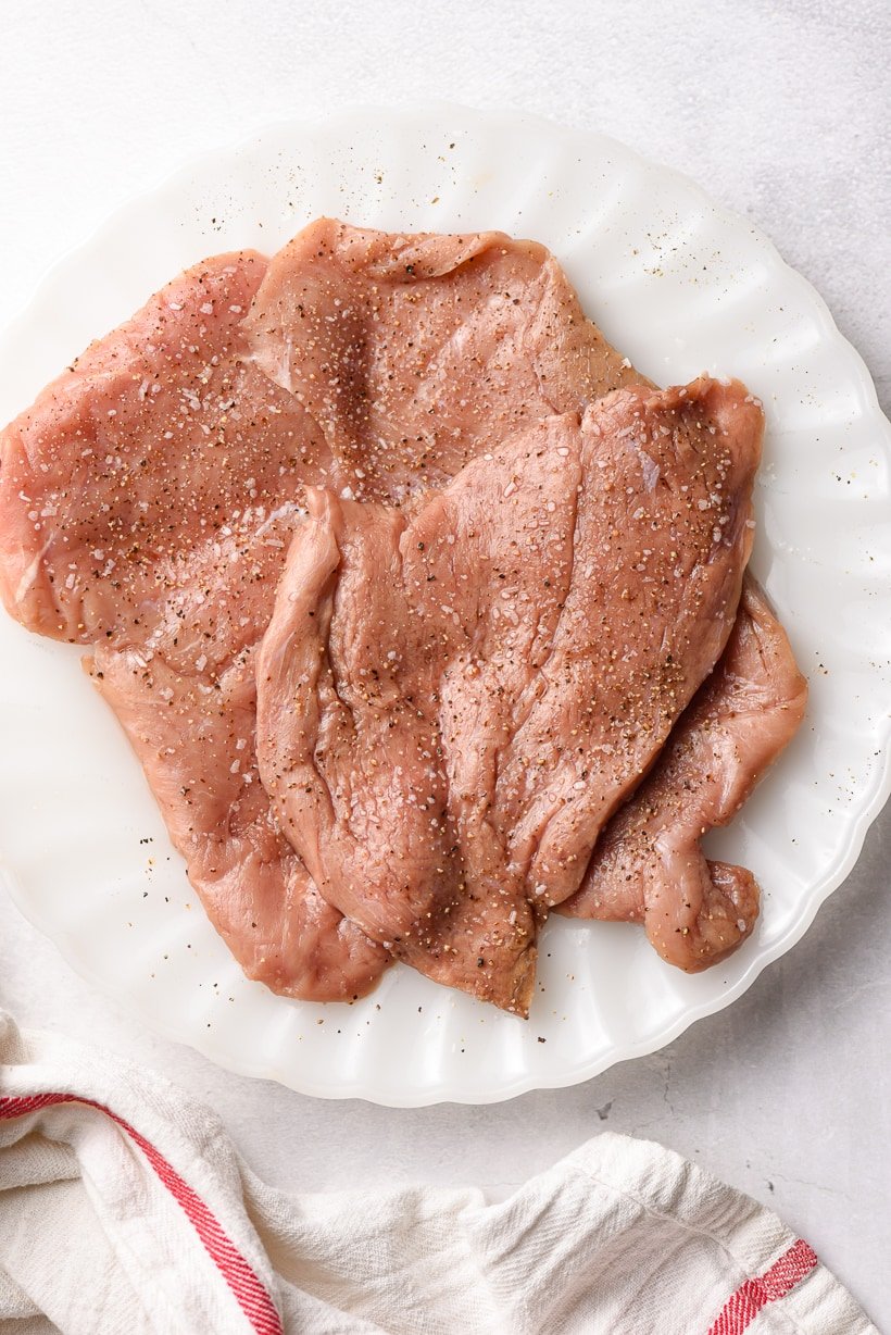 raw veal scallopini on a plate