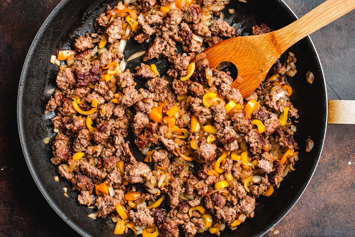 Saute pan with ground beef, onions, and peppers.