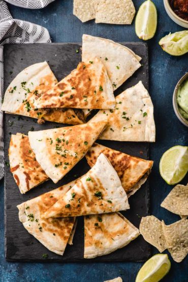 platter of ground beef quesadillas with lime and chips