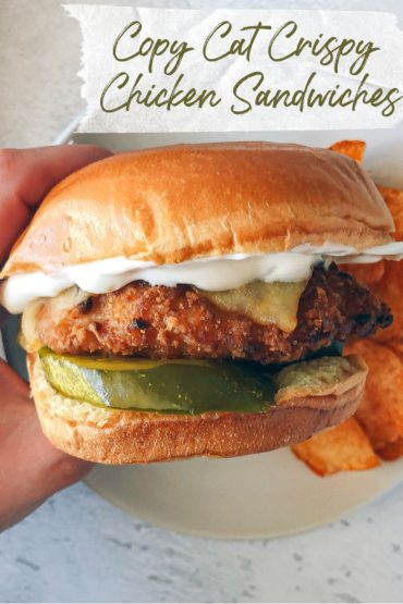 Hand Holding a Crispy Chicken Sandwich with Pickles