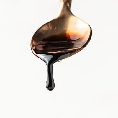 balsamic reduction dripping off a gold spoon