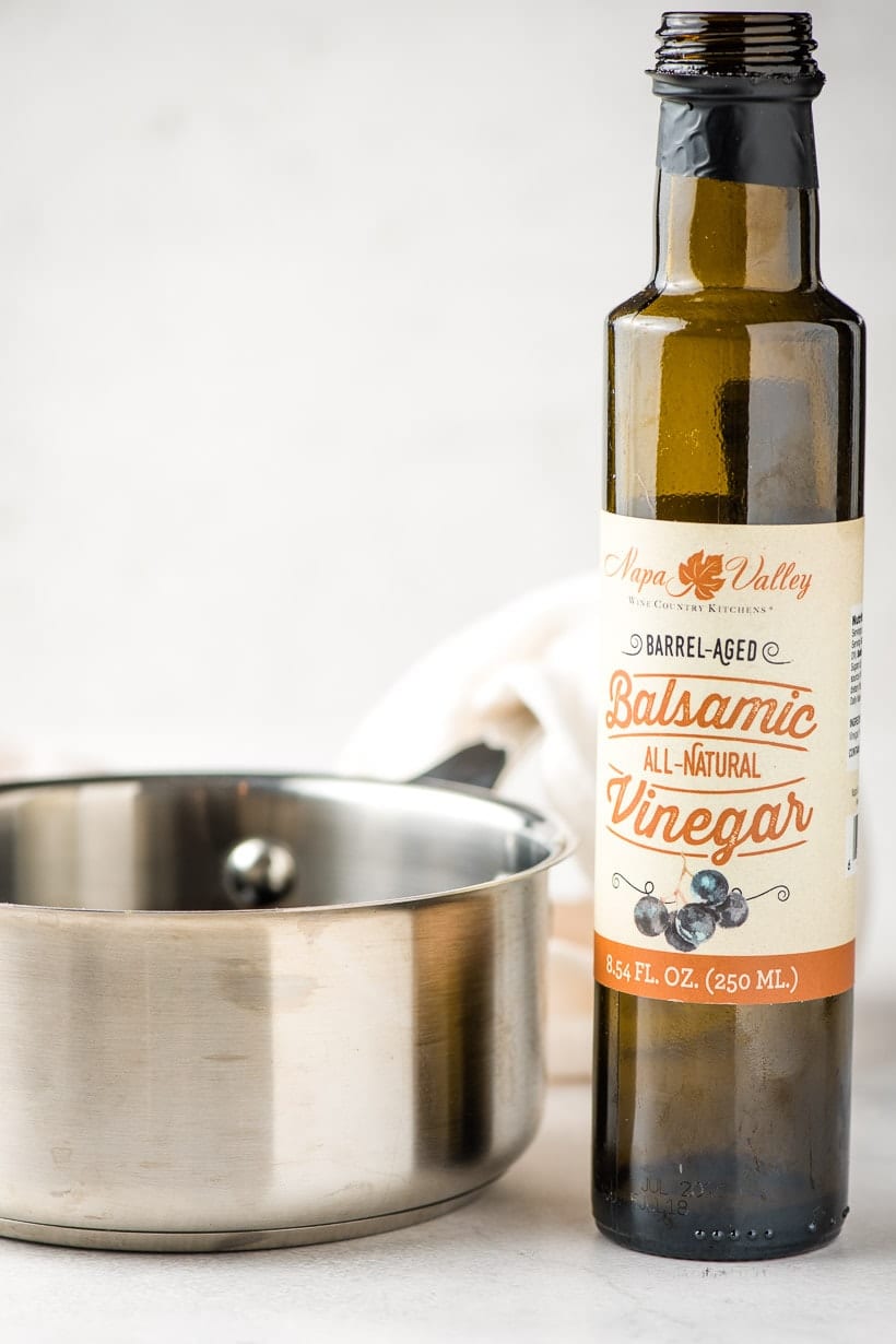 bottle of balsamic vinegar beside a sauce pot