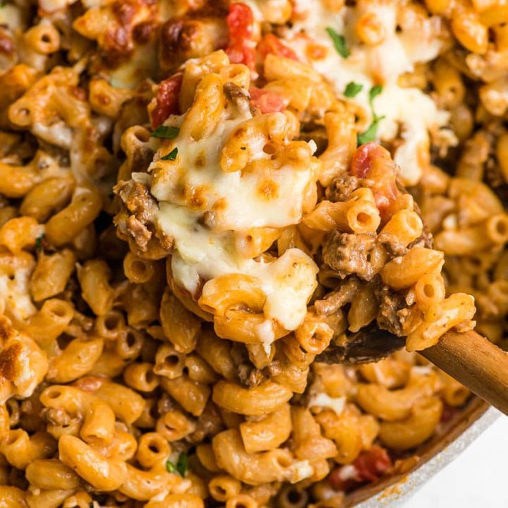 wooden spoon scooping cheeseburger pasta out of a pan