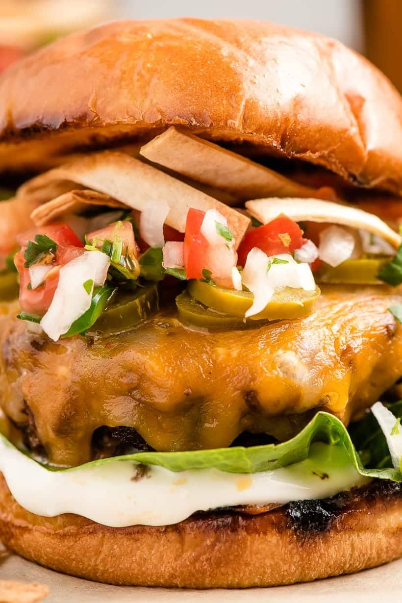 up close shot of taco burger with pico de gallo and sour cream