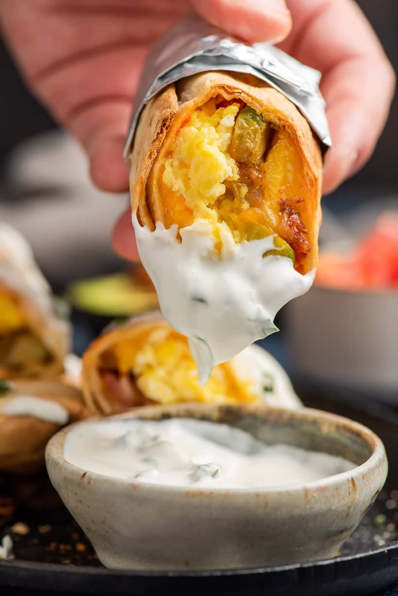Breakfast Burrito being dipped into sauce