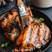 asian chicken marinade sauce is brushed onto grilled chicken