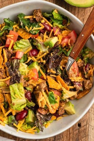 Taco Salad with ground beef and doritos in a white bowl.