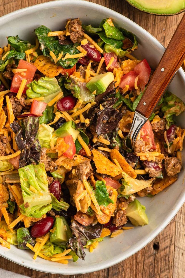 Taco Salad with ground beef and doritos in a white bowl.