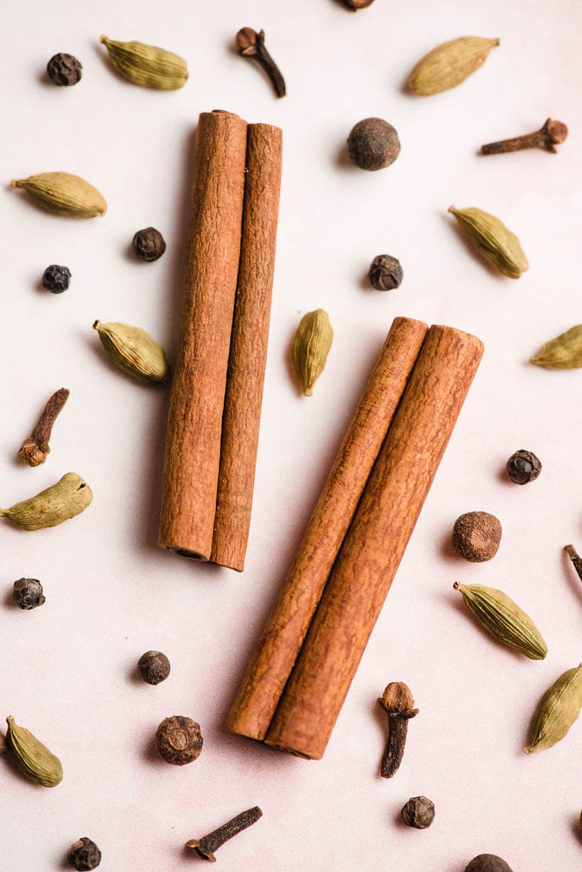 chai spices arranged on a pink background