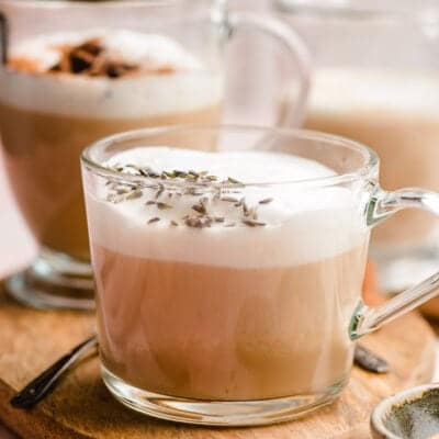 earl gray tea latte in a glass mug, sprinkled with lavender buds