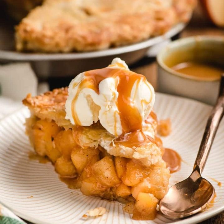 slice of homemade apple pie with caramel and ice cream