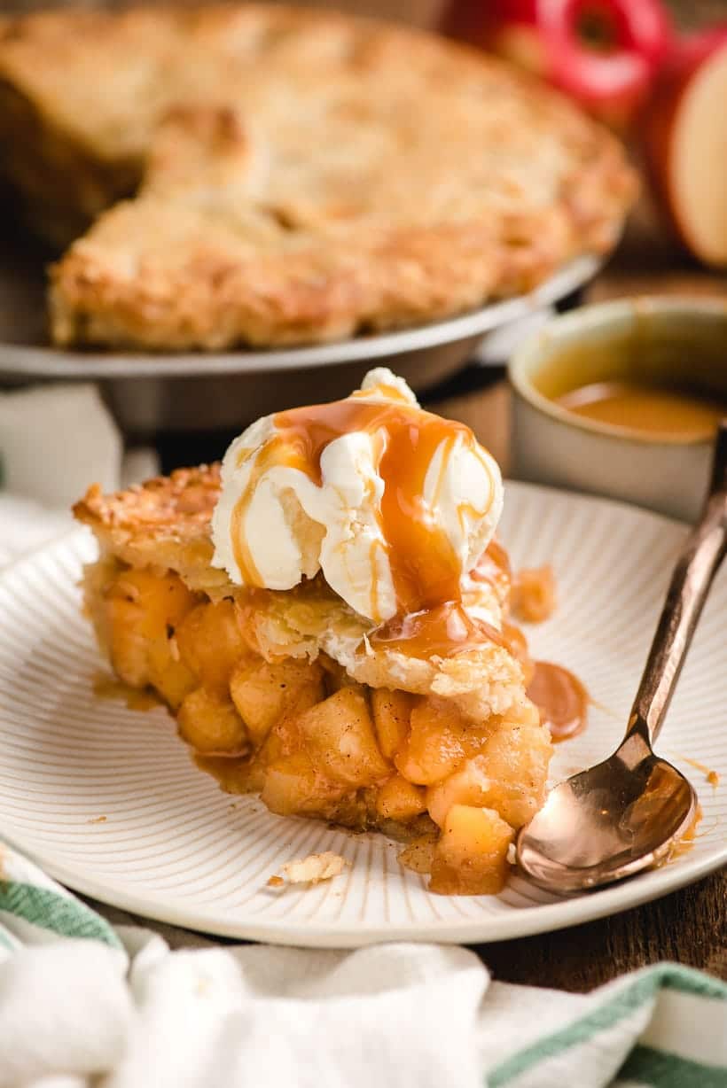 slice of homemade apple pie with caramel and ice cream