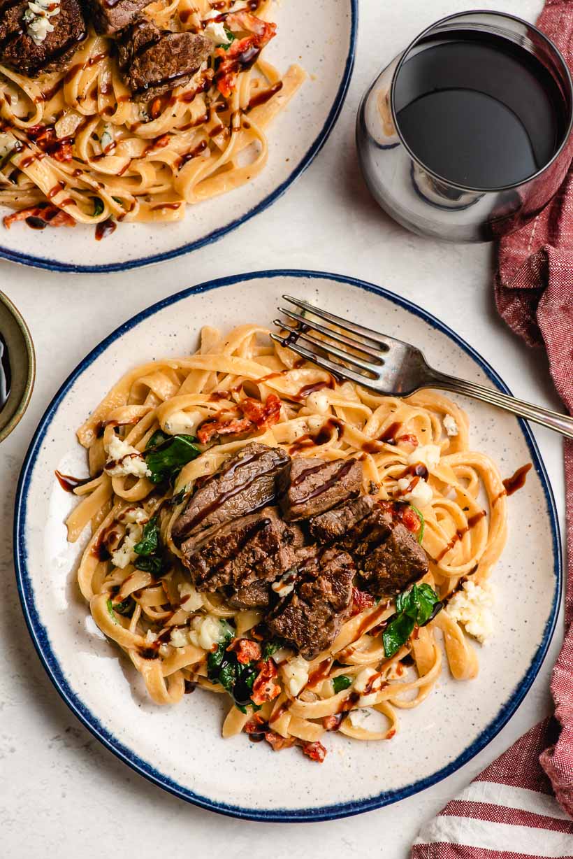 two white plates with creamy steak fettuccine